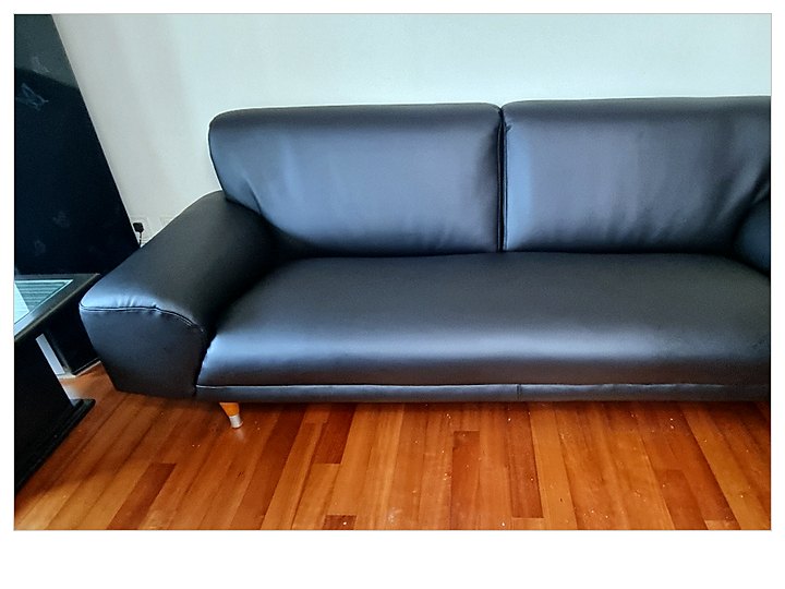 원목 마루에 놓인 차콜 가죽 소파